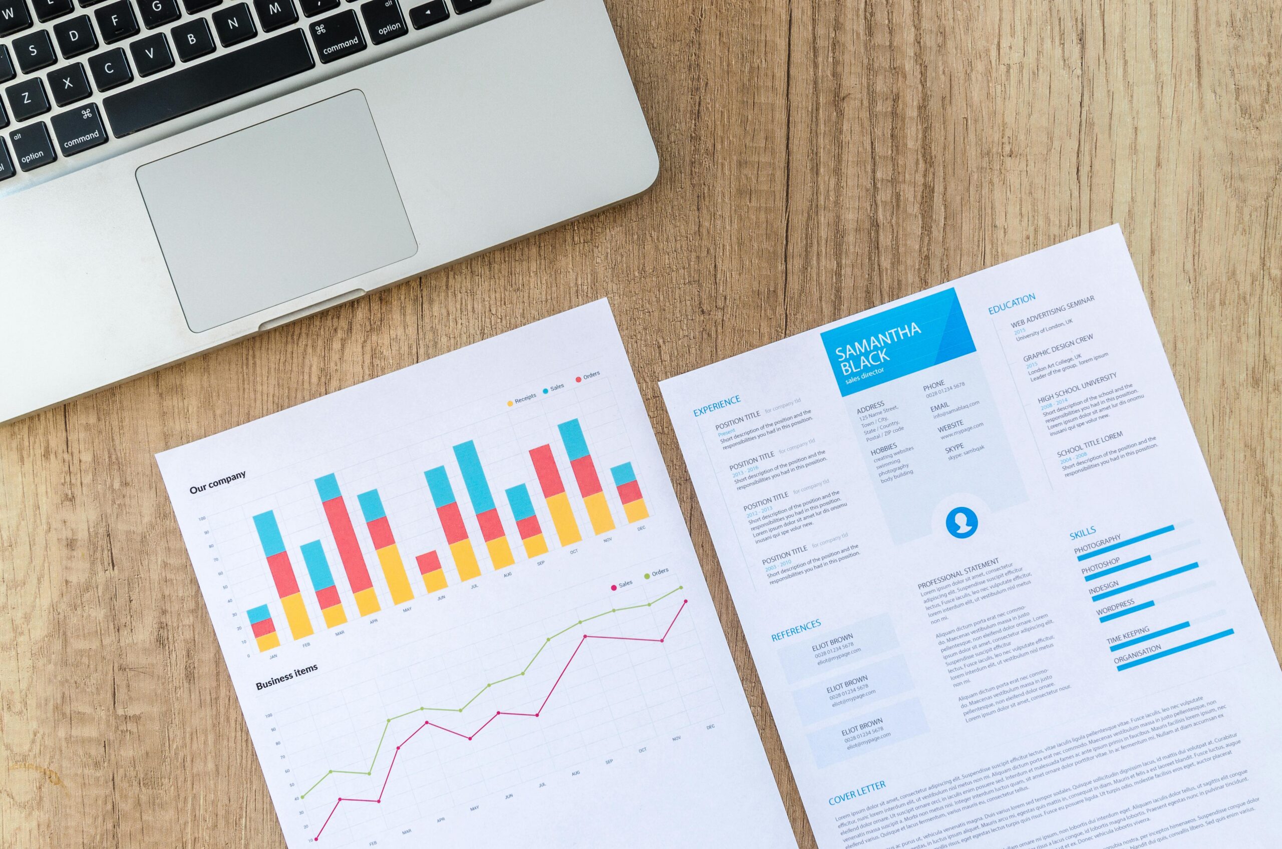 Ноутбук и финансовые отчёты на столе, иллюстрация к расходам компаний на LLM
